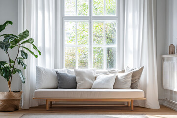 Bright and airy living room featuring a minimalist sofa with decorative pillows and a large window overlooking greenery