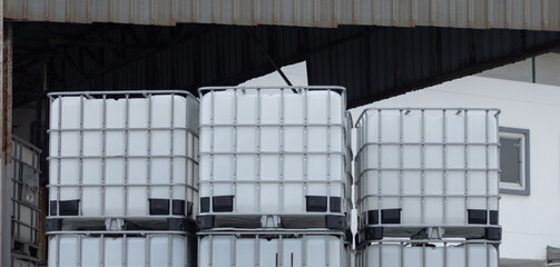 A stack of white plastic containers are piled on top of each other. Stacked IBC Containers.