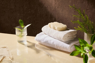 The advertising photo from high angle view with spa concept, product displaying space on beige table top, which featuring glass jars , green plants, spa towel and soap on