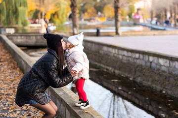 Mother and daughter walking in the Park and enjoying the beautiful autumn nature together