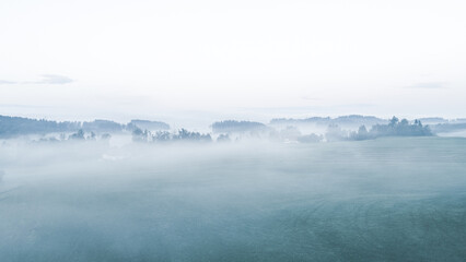 Aerial panoramic view of misty morning with dense fog, serene countryside landscape