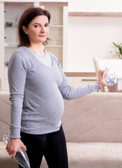 Aged pregnant woman doing exercises at home