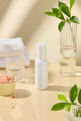 The advertising photo of cosmetic product with natural and spa concept, blank label cosmetic bottle in white placed in center, spa items displayed around. High angle shot, blank space for text