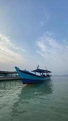 Bandar Lampung, Indonesia - September 1st 2024: Fishing boats are parked on the seashore in the afternoon with a cloudy sky in the background