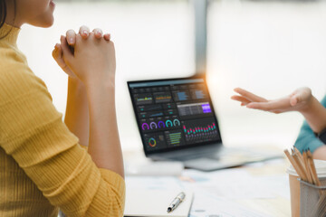 Collaborative business meeting with data analysis on laptop screen.