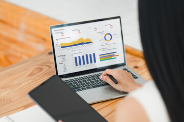 Businesswoman interacts with a digital sales dashboard displaying various performance metrics and analytics.