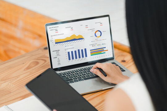 Businesswoman interacts with a digital sales dashboard displaying various performance metrics and analytics.