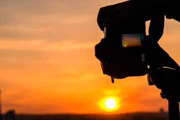 Zachód słońca widziany na ekranie nowoczesnego aparatu fotograficznego, zdjęcia w plenerze 