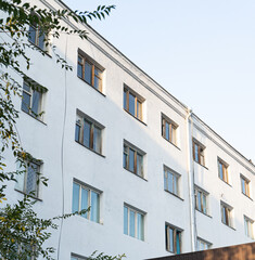 A modern apartment building bathed in soft daylight, showcasing clean architectural lines and well-maintained exterior. The photo captures the minimalist design and urban living atmosphere 