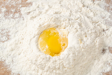 Crack egg inthe flour. Preparing dough, eggs and flour.	