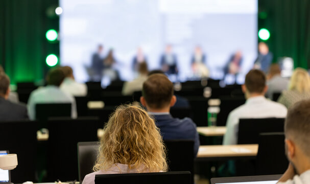 Rear view of the audience at a business conference meeting event listening to the speakers speech