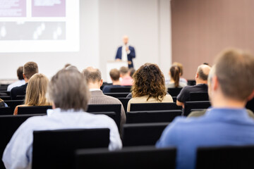 Rear view of the audience at a business conference meeting event listening to the speakers speech