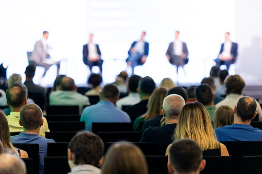 Rear view of the audience at a business conference meeting event listening to the speakers speech