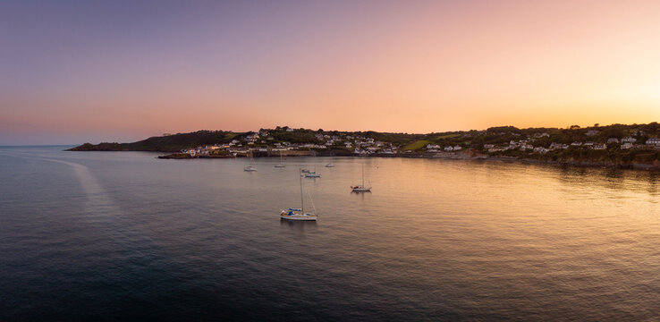 Sailing yachts take shelter for the evening at sunset in Coverack.