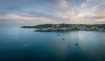 Sailing yachts take shelter for the evening at sunset in Coverack.
