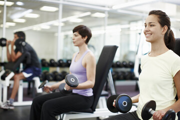Fototapeta premium Fitness, smile and dumbbells with woman in gym for training, muscle connection and workout. Personal trainer, strong and sports athlete with person and exercise for energy, wellness and weights