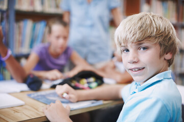 Portrait, child and education with books in library for assessment research, learning notes and...