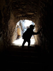 a man is standing in a cave with a shadow on the wall.