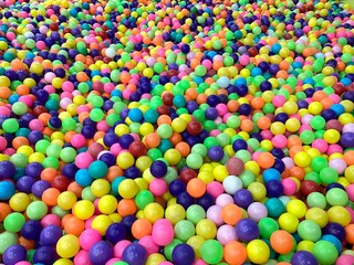 Thousands of colorful plastic balls in a pool known as a ball pool in the indoor kids zone