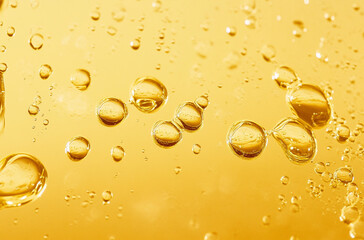 close up of yellow oil bubbles in liquid
