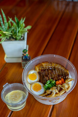 a bowl of rice topped with chashu pork and seasoned boiled egg
