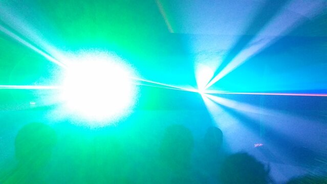 Clubbing Techno Rave in a Club Disco with immensive Light and Laser Show | Series with different colors and some diffuse peope in the foreground