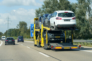 Naklejka premium Transportation of cars on a special vehicle along the highway.