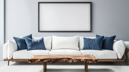 Live edge accent coffee table near white sofa with blue pillows against wall with big poster frame Coastal home interior design of modern living room