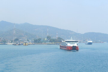 The red passenger ship contrasts with the blue sky and blue sea
