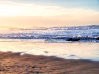 Fototapeta premium Atardecer en la playa de Santander con las olas rompiendo en la orilla