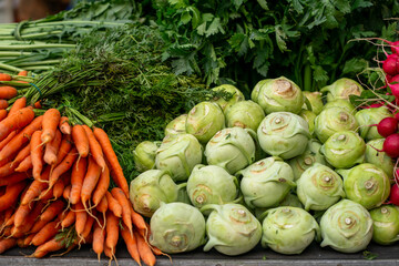 Various stacks of vegetables lie on the table for sale at the market
