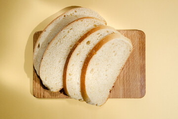 Freshly cut white sourdough bread on a wooden board. Delicious pastries for breakfast
