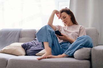 Obraz premium Young female chatting in social network or surfing internet, shopping online.