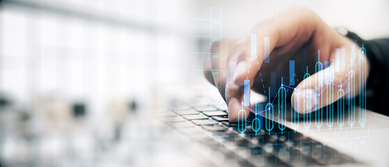 Businessperson typing on a laptop with financial graphs overlay on a light background, representing financial analysis and technology.