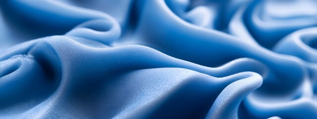 Obraz premium A close-up of blue foam material, showcasing its soft and voluminous appearance with swirling shapes and curves. The focus is on the texture's unique quality in high resolution.