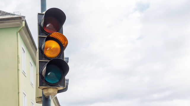 Traffic light showing red, yellow, and green lights at city intersection, urban transportation concept