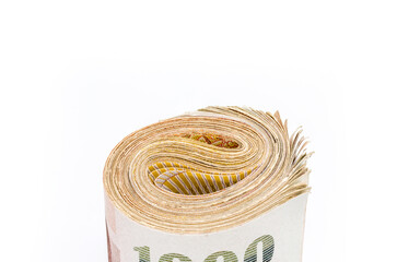 Thai money roll tightened with green rubber band. Rolled money isolated on white.