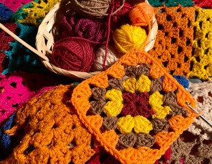 Crochet granny square, clews and hook on crochet blanket background photo