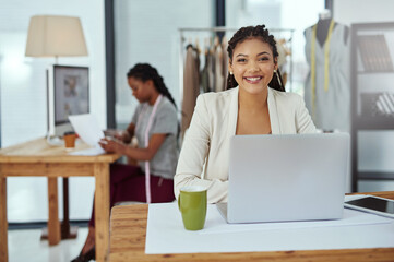 Happy woman, portrait and fashion designer with laptop for clothing production or manufacturing at workshop. Young, female person or dressmaker with smile on computer for design or garment industry