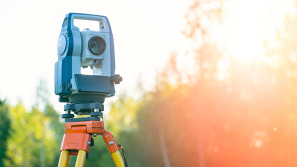 A surveying instrument is set up in a field. The instrument is a total station, which is used to...