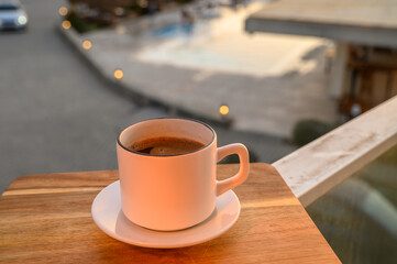 Black coffee in a mug on the background of the pool