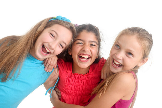 multiethnic group of three cheerful preteen girls having fun on isolated white background