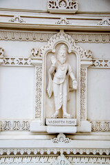 A white marble sculpture of a Hindu saint in the temple. Oldest temple in India. Beautiful sculpture of ancient India 13th century. Wall mounting background. Wall poster. 
