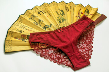 Red women's panties with a fan on a white background