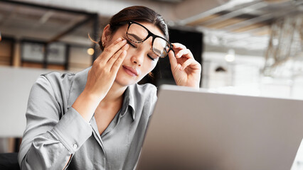 Tired business woman touching her eye