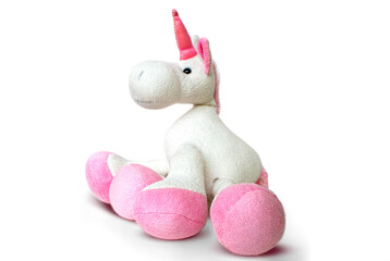 Image of a pink soft unicorn toy sitting at white background. Isolated studio image. High quality photo