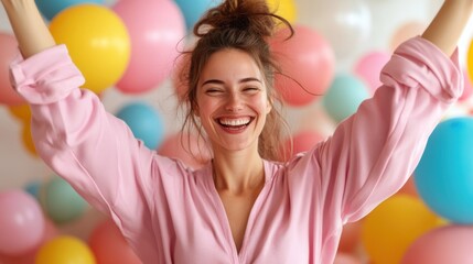 Obraz premium A jubilant woman in pink joyfully celebrates amidst a vibrant array of colorful balloons, capturing exuberance and the festive spirit in a lively setting.