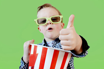 Little cute fun kid baby boy 3-4 years old in red t-shirt holding bucket for popcorn, eating fast food isolated on yellow background. . High quality photo