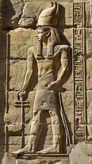 Obraz premium Ancient Egyptian hieroglyphs depicting an ancient man in simple with his hands raised, carved on the wall of one of Egypt's main temples.