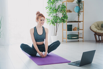 Photo of active charming pretty woman wearing activewear watching video doing physical exercises from home indoors